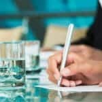 Person taking notes during a business meeting on log keeping.