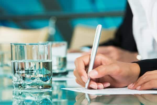 Person taking notes during a business meeting on log keeping.