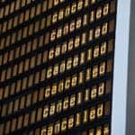 Flight cancellation display at Manchester Airport showing multiple cancellations.